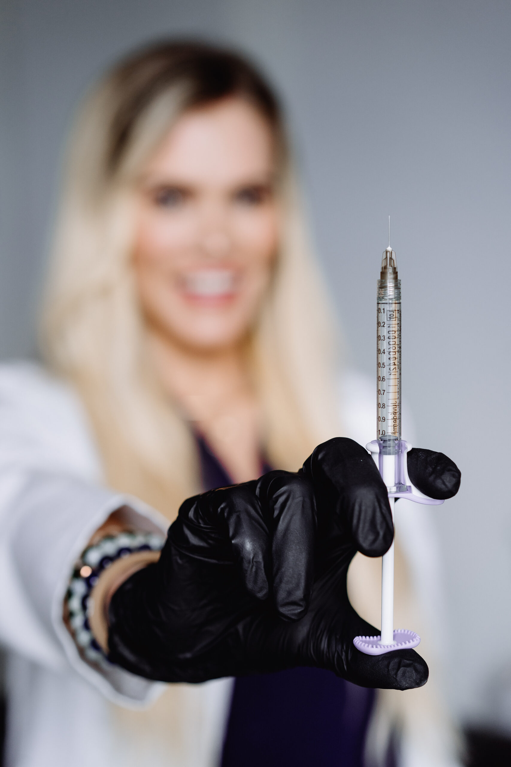 Be You Medical nurse holding a syringe filled with Restylane filler